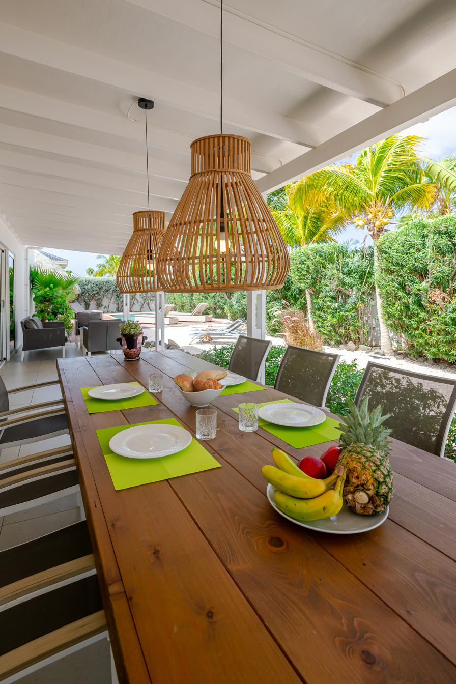Covered terrace with a long outdoor dining table for eight